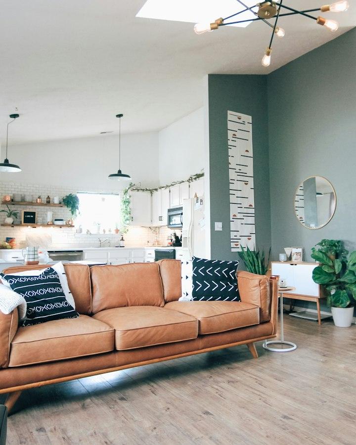 Finished living room with a tan sofa and pendant lights