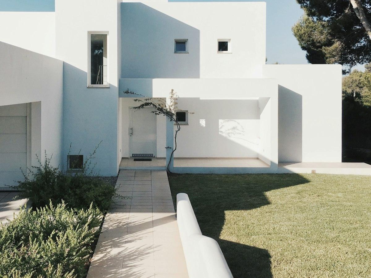 White cubic house with a garden path