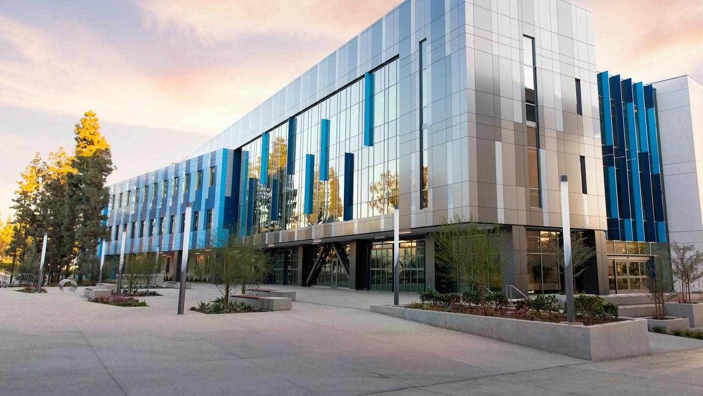 Modern office building with a glass and metal facade at sunset