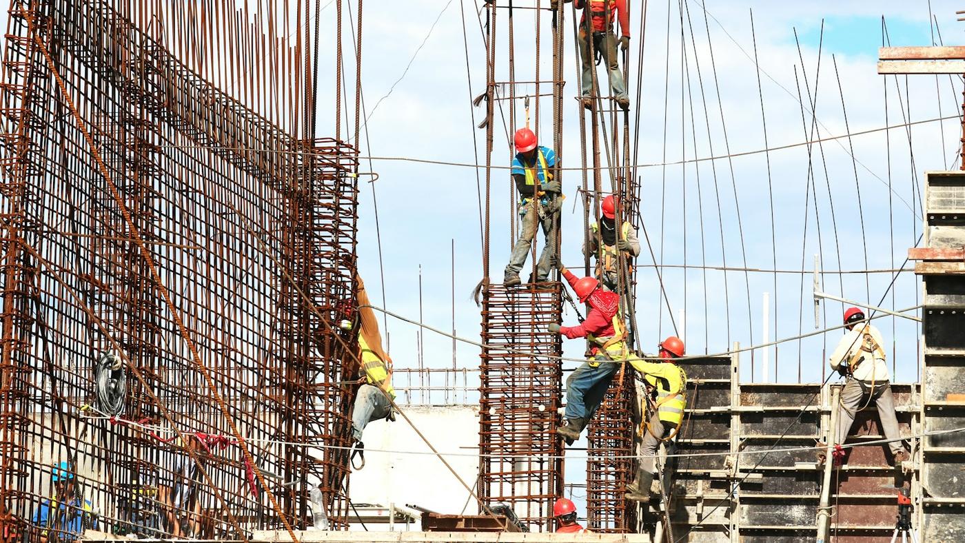 Workers fixing steel reinforcement cages on a building site