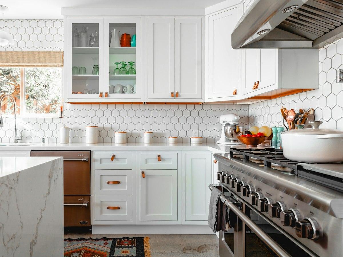 White kitchen with a marble island and hexagon tiles