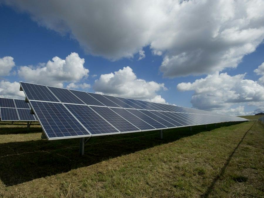 Rows of solar panels in a green field